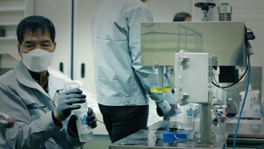 삼성의 스마트공장 지원을 받은 전라북도 군산시에 위치한 손세정제 제조업체 '앤제이컴퍼니' 직원이 손세정제 용기와 분무기를 연결하고 있다. <삼성전자 제공>